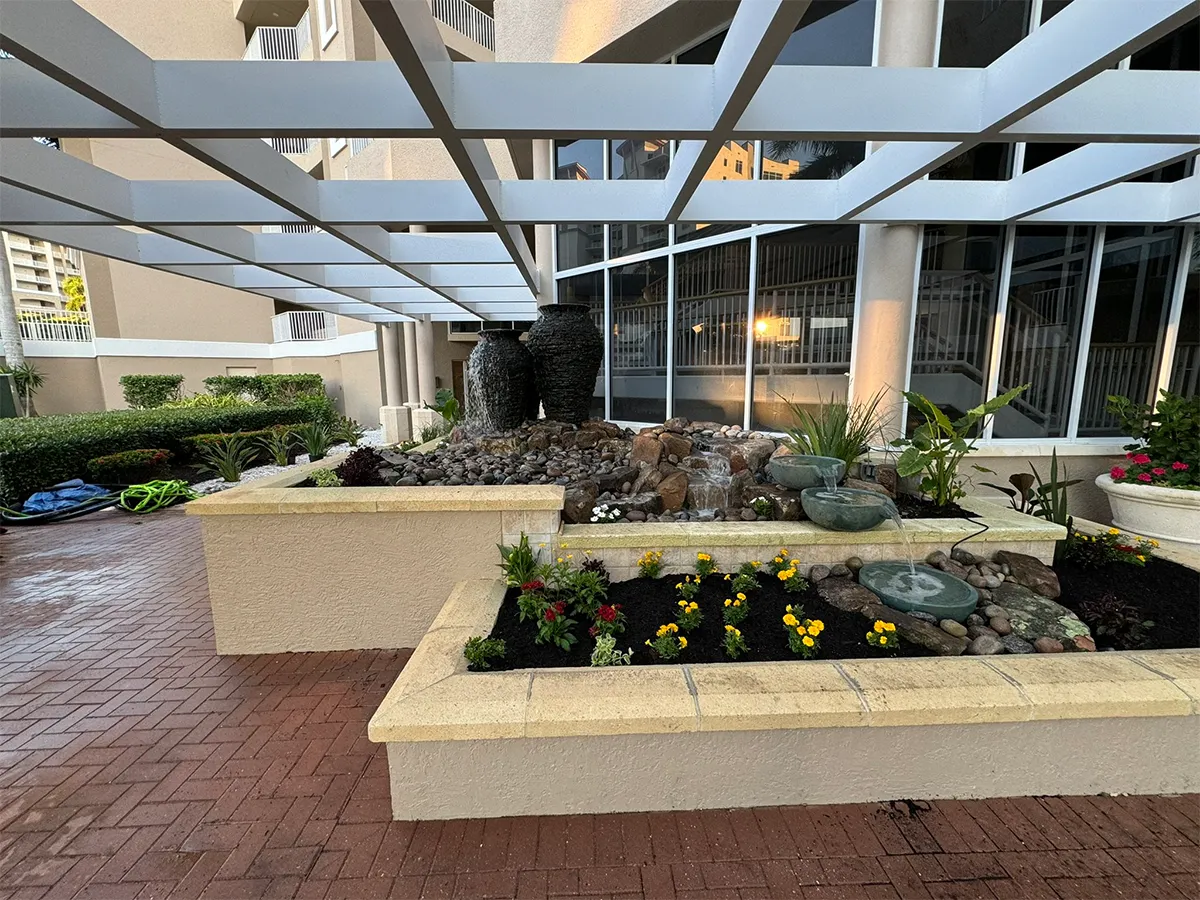 Completed commercial water fountain with decorative planters and running water.