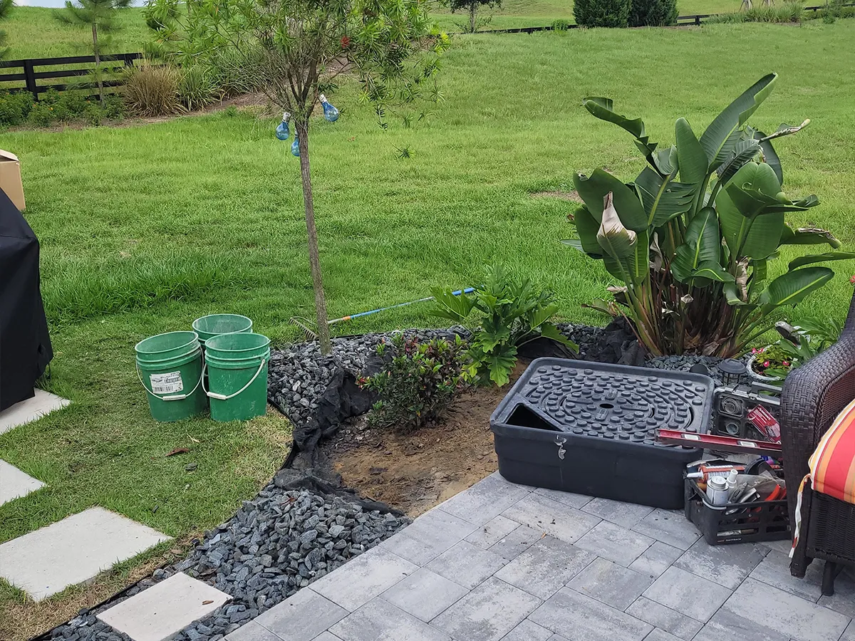 Backyard landscaping with materials and tools ready for a fountain installation