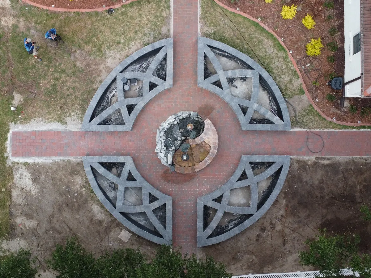 Aerial view of a newly constructed fountain base with a geometric pattern in a residential yard