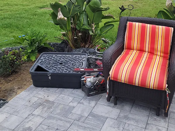 Fountain repair setup on a patio, showcasing tools and equipment used in water feature maintenance and restoration.