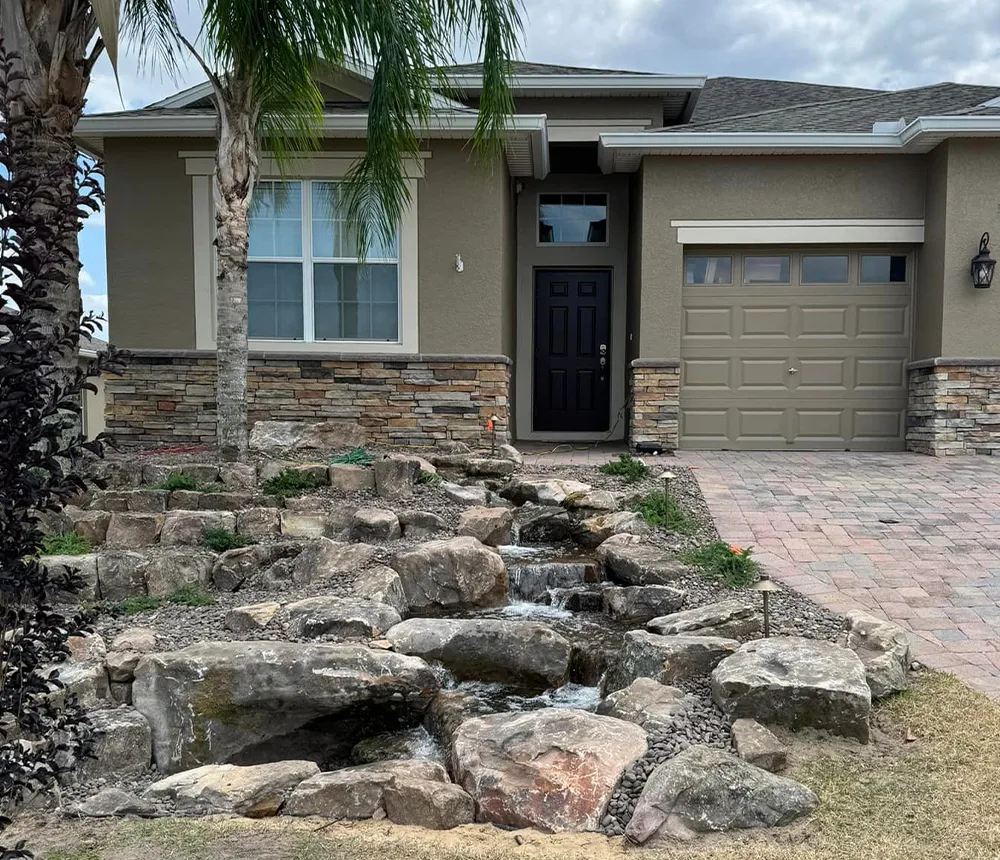 Front yard natural stone waterfall feature with tiered rock design